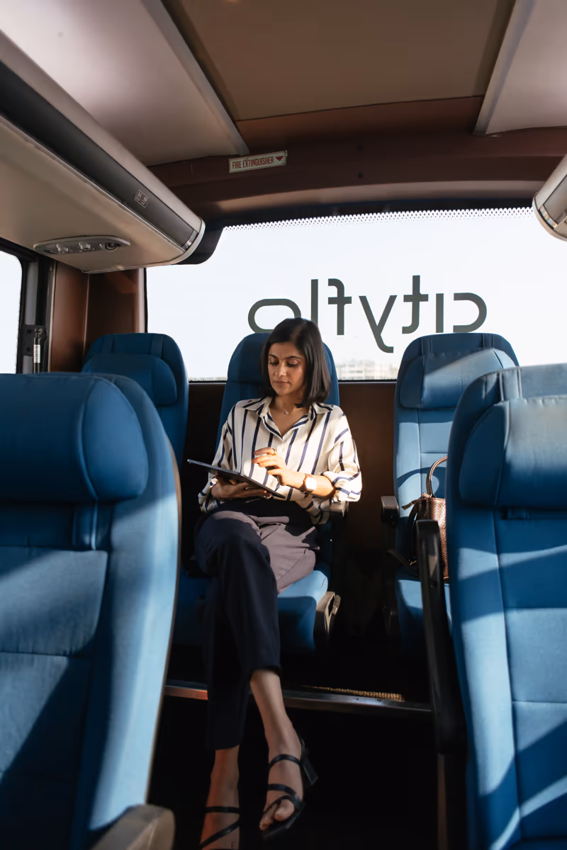A commuter working on a tablet aboard a Cityflo bus